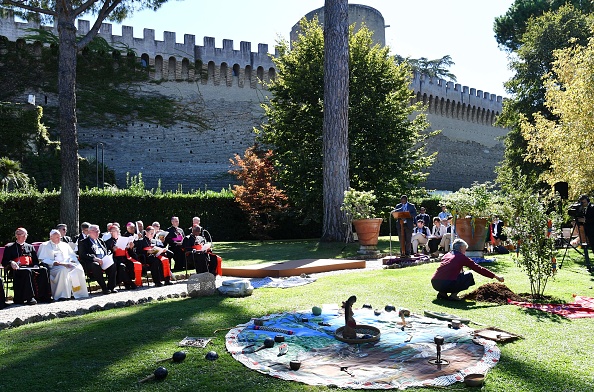 -Le pape François observe un représentant des communautés amazoniennes en train de planter un arbre dans les jardins du Vatican avant le synode amazonien. Les communautés indigènes de la région amazonienne auront une voix au Vatican à partir d'octobre 6, 2019. Photo de ANDREAS SOLARO / AFP via Getty Images.