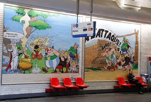 -Illustration- Une femme est assise devant un dessin spécialement conçu pour commémorer le 60e anniversaire des célèbres personnages de bande dessinée français Astérix et Obélix le 9 octobre 2019. Photo FRANCOIS GUILLOT / AFP via Getty Images.