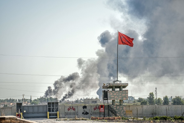 Une photo prise à Akcakale à la frontière turque avec la Syrie le 10 octobre 2019 montre des fumées émanant de la ville syrienne de Tal Abyad après qu'un mortier soit tombé dans le jardin d'un bâtiment du gouvernement turc à Akcakale. (Photo : BULENT KILIC/AFP via Getty Images)