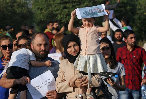 -Une famille kurde prend part à une manifestation à Arbil, capitale de la région autonome kurde du nord de l'Irak, le 10 octobre 2019, contre l'offensive turque dans le nord-est de la Syrie. Les Kurdes syriens se sont battus pour repousser l'invasion Turque, cette guerre pourrait remodeler le pays et déclencher une crise humanitaire. Photo de SAFIN HAMED / AFP via Getty Images.