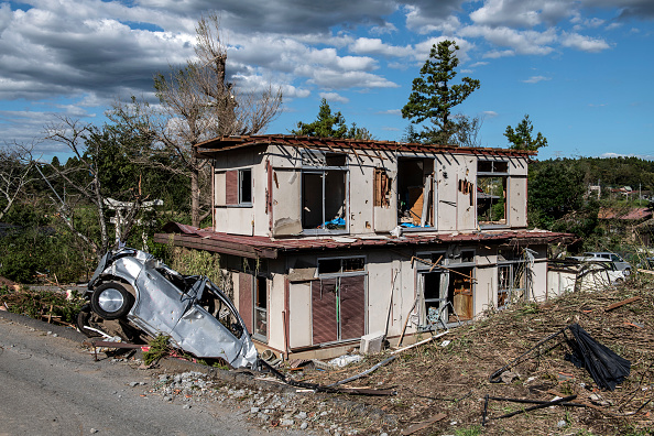 Une voiture retournée gît à côté d'une maison partiellement détruite après avoir été touchée par une tornade peu avant l'arrivée du typhon Hagibis, le 13 octobre 2019 à Chiba. (Photo : Carl Court/Getty Images)