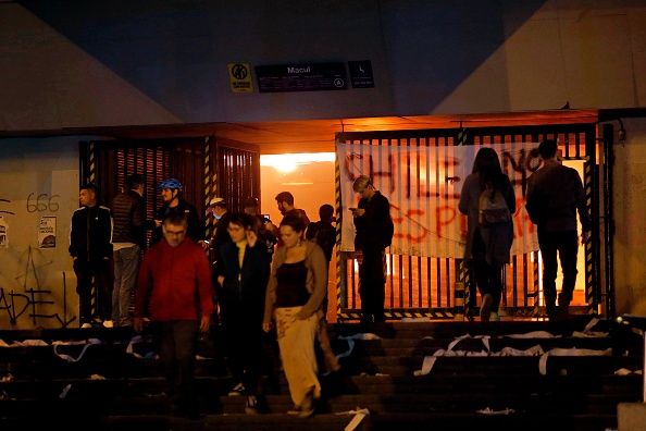 -Vue de la station de métro Macul incendiée par des manifestants lors d'une protestation de masse à Santiago, le 19 octobre 2019. L'ensemble du métro de Santiago, qui mobilise environ trois millions de passagers par jour, a cessé ses activités vendredi après-midi à la suite d'attaques, à cause de l’augmentation du billet. Photo de JAVIER TORRES / AFP via Getty Images.