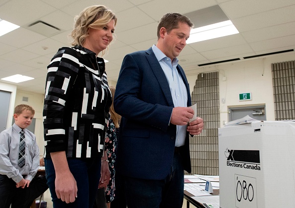 Le 21 octobre 2019, le chef conservateur Andrew Scheer et son épouse Jill Scheer attendent pour voter dans un bureau de vote de leur circonscription, à Regina, en Saskatchewan. Des sondages ont permis de prédire que le Parti libéral du Premier ministre Justin Trudeau pourrait revenir avec un gouvernement minoritaire affaibli ou perdre totalement son emprise sur le pouvoir. Photo par ADRIAN WYLD / POOL / AFP via Getty Images.