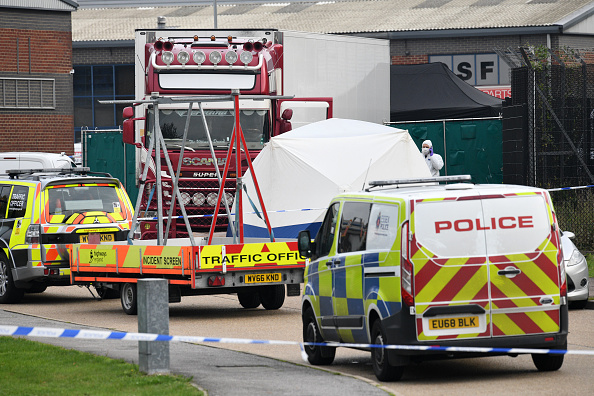 -La police et les médecins légistes enquêtent sur un camion dans lequel 39 corps ont été découverts dans la remorque, alors qu'ils préparent le déplacement du véhicule du site le 23 octobre 2019 à Thurrock, en Angleterre. Photo de Leon Neal / Getty Images.