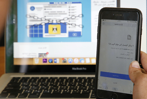 -Une photo prise le 23 octobre 2019 montre un Palestinien tenant un téléphone portable portant le message "ce site Web n'est pas accessible", dans un bureau de la ville de Hébron, en Cisjordanie, à la suite de la décision d'un tribunal de Ramallah d'interdire l'accès au site et des dizaines de sites. Photo de HAZEM BADER / AFP via Getty Images.