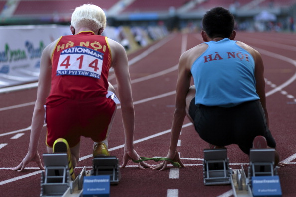 -Illustration- Manh Tung du Vietnam et son partenaire de course s'assoient sur la ligne de départ avant de prendre part à la course de sprint sur 100m lors de la 7ème édition des Jeux paranéens de l'ANASE qui se sont déroulé au Complexe sportif Wunna Theikdi le 15 janvier 2014 en Birmanie. Photo de Ruben Salgado Escudero / Getty Images.