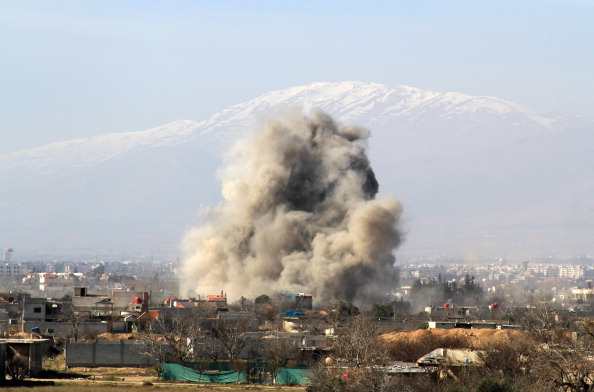 -Illustration- La fumée monte après qu'un hélicoptère aurait largué l'une des deux barils de bombes sur la ville. Photo FADI DIRANI / AFP / Getty Images.