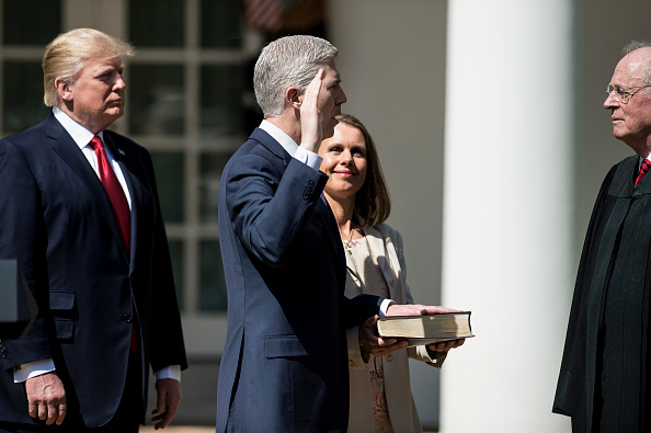 -Le président des États-Unis, Donald Trump et Louise Gorsuch observent le juge de la Cour suprême, Anthony Kennedy, faire prêter serment à Neil Gorsuch lors d'une cérémonie qui s'est déroulée dans la roseraie de la Maison-Blanche le 10 avril 2017 à Washington, DC. Photo BRENDAN SMIALOWSKI / AFP / Getty Images.