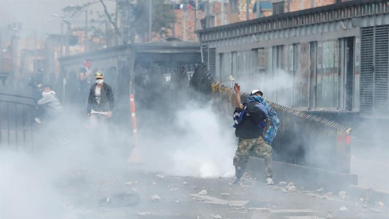 Des manifestants à capuche sont confrontés ce vendredi à la police anti-émeute dans un secteur de Patio Bonito, au sud de Bogotá, en Colombie. EFE/ Mauricio Dueñas Castañeda