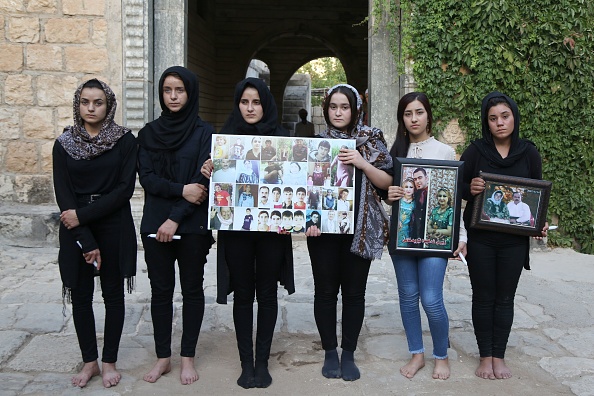 -Illustration- La femme yézide Ashwaq Haji qui aurait été utilisée comme esclave sexuelle par le groupe État islamique pose pour une photographie en hommage aux victimes des jihadistes de son village de Kocho, près de Sinjar, avec leurs proches. Comme beaucoup d'autres Yézidis, elle a été kidnappée par l'EI lorsque les djihadistes ont saisi des étendues d'Irak à l'été 2014. Photo de  / AFP via Getty Images.