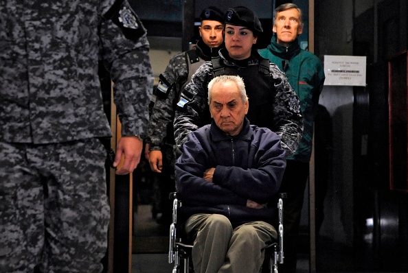 Le prêtre catholique italien Nicola Corradi (Centre) et le prêtre catholique argentin Horacio Corbacho (Droite) sont escortés dans une salle d'audience pour leur procès concernant des allégations d'abus sexuels à Mendoza, Argentine, le 5 août 2019. (ANDRES LARROVERE/AFP via Getty Images)