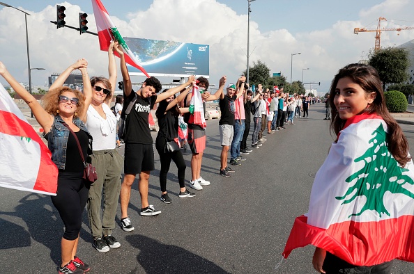 -Les manifestants libanais s'unissent pour former une chaîne humaine le long de la côte du nord au sud, symbole de l'unité, lors des manifestations antigouvernementales en cours dans la capitale libanais, Beyrouth. Photo ANWAR AMRO / AFP via Getty Images.