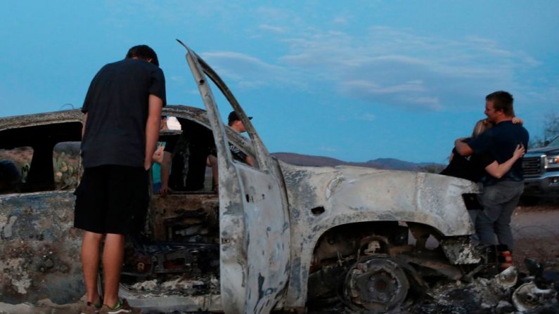 Des membres de la famille Lebaron regardent la voiture brûlée où une partie des neuf membres assassinés de la famille ont été tués et brûlés lors d'une embuscade à Bavispe, dans les montagnes Sonora, au Mexique, le 5 novembre 2019. - Le président américain Donald Trump a offert le 5 novembre d'aider le Mexique à "faire la guerre" à ses cartels après que trois femmes et six enfants d'une communauté mormone américaine ont été assassinés dans une région connue pour ses trafiquants de drogue. (Photo par Herika MARTINEZ / AFP / Getty Images) 