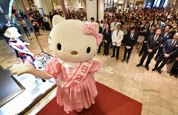 -Illustration- Directeur d'un jour du grand magasin Mitsukoshi dans le somptueux quartier de Ginza à Tokyo, pose avec des employés lors d'une réunion le matin avant l'ouverture, le 1er novembre 2014 Photo KAZUHIRO NOGI / AFP via Getty Images.