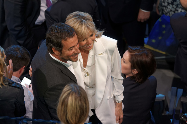 Bernard Montiel et Brigitte Macron prennent la pose pendant un rallye d’Emmanuel Macron, alors candidat aux élections présidentielles, organisé le 17 avril 2017 à Bercy. Crédit : Lefevre/Getty Images.