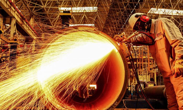 Un ouvrier coupe le tuyau d’oléoduc dans une usine de Qingdao, dans la province chinoise du Shandong, le 28 février 2019. (STR/AFP/Getty Images)