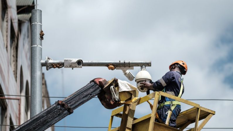 Un travailleur nettoie une caméra de surveillance dans une rue de Nairobi, au Kenya, le 18 janvier 2019. (YASUYOSHI CHIBA/AFP via Getty Images)