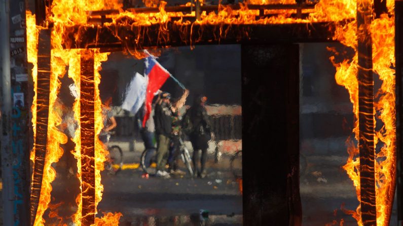 Un manifestant agite un drapeau chilien lors d'une manifestation contre le président Sebastian Piñera le 21 octobre 2019 à Santiago du Chili. (Marcelo Hernández / Getty Images)