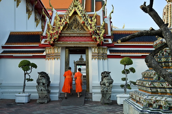 -Sur cette photo prise le 3 décembre 2019, des moines bouddhistes entrent dans un temple du complexe du Wat Po à Bangkok. Largement pratiqué à travers la Thaïlande, des spas haut de gamme de Bangkok et des plages de Phuket aux modestes entreprises locales, "nuad" qui signifie massage est en cours d'examen par le comité de l'UNESCO lors de sa réunion du 9 au 14 décembre à Bogota. Photo de ROMEO GACAD / AFP via Getty Images.