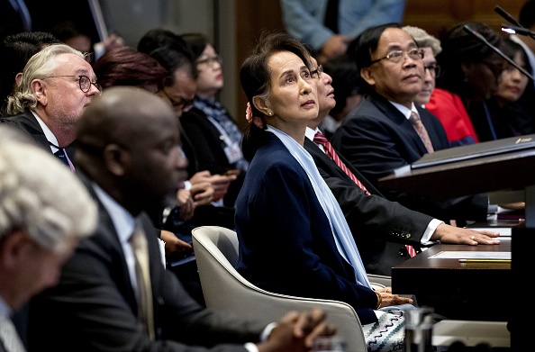 La cheffe la cheffe de facto du gouvernement birman  Aung San Suu Kyi (centre) se tient devant la Cour internationale de Justice des Nations Unies le 11 décembre 2019 à côté d'Abubacarr Tambadou (2e de gauche), ministre de la Justice de la Gambie, au Palais de la Paix de La Haye, le deuxième jour de son audition sur le génocide des Rohingyas. (Photo : KOEN VAN WEEL/ANP/AFP via Getty Images)