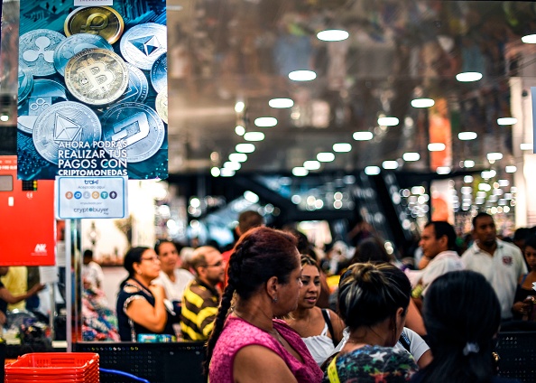 -Les clients font la queue aux caissiers d'un magasin qui accepte la crypto-monnaie vénézuélienne Petro, à Caracas, le 28 décembre 2019. Photo de Yuri CORTEZ / AFP via Getty Images.