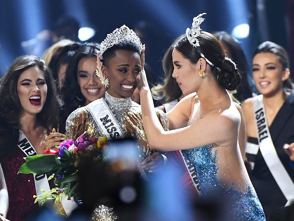 -Miss Univers 2019 Zozibini Tunzi, d'Afrique du Sud, est couronnée sur scène par Miss Univers 2018 Catriona Gray, au concours Miss Univers 2019 le 08 décembre, 2019 à Atlanta, Géorgie. (Photo : Paras Griffin / Getty Images.)