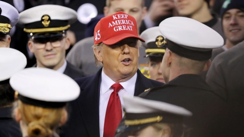 Le président américain Donald Trump se tient aux côtés de la marine pour entamer la deuxième moitié du match entre les Chevaliers noirs de l'armée de terre et les marins de la marine au Lincoln Financial Field le 14 décembre 2019 à Philadelphie, Pennsylvanie. (Photo par Elsa/Getty Images)