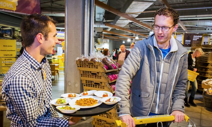 Un employé offre des échantillons de collations à base d'insectes à un client dans un magasin de la chaîne de supermarchés néerlandaise Jumbo à Groningen (Remko de Waal / AFP / Getty Images)