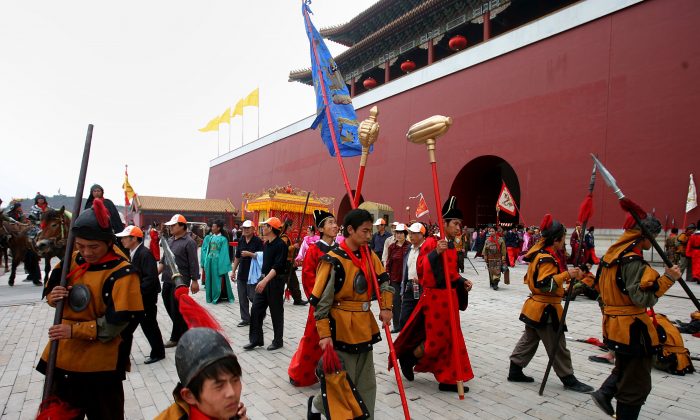 Des figurants vêtus de costumes datant de la dynastie Qing se reposent dans un lieu de tournage de la base de tournage de films et de télévision de Hengdian le 12 mai 2006 à Dongyang dans la province du Zhejiang, en Chine. (Photos de Chine / Getty Images)