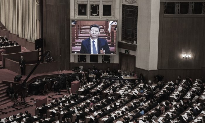 Le dirigeant chinois Xi Jinping vu sur un grand écran au-dessus des délégués alors qu'il se joint à une session de l'Assemblée populaire nationale tenue au Grand palais du Peuple à Pékin, le 11 mars 2018. (Kevin Frayer/Getty Images)
