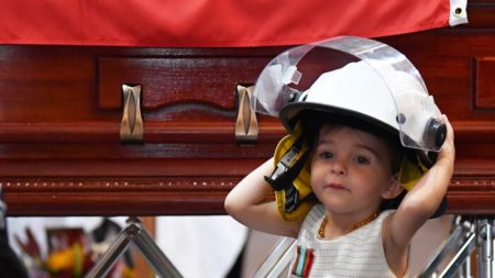 La fillette d’un pompier mort en service reçoit sa médaille de bravoure lors de ses funérailles