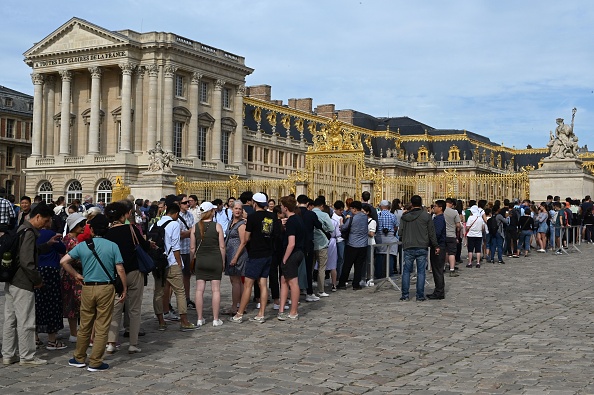 -Les touristes font la queue pour entrer et visiter le château de Versailles, la principale résidence royale de France de 1682, sous Louis XIV, jusqu'au début de la Révolution française en 1789, à quelque 20 kilomètres au sud-ouest de la capitale française Paris le 18 juin 2019. Photo de Dominique FAGET / AFP via Getty Images.