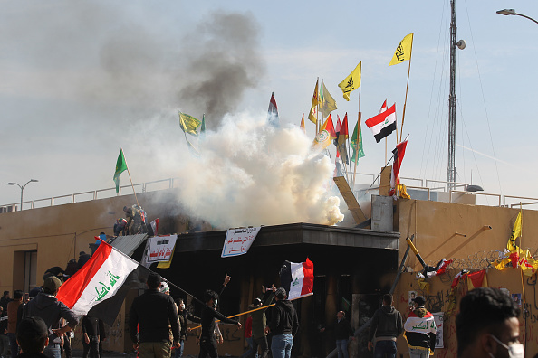 -Les forces américaines (invisibles) tirent des cartouches de gaz lacrymogène sur des partisans et des membres des forces paramilitaires de Hashed al-Shaabi lors d'une manifestation devant l'ambassade des États-Unis à Bagdad, la capitale irakienne, le 1er janvier 2020. Photo par AHMAD AL-RUBAYE / AFP via Getty Images.