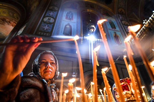 -Illustration- Un croyant orthodoxe russe allume une bougie alors qu'elle assiste à un service de Noël dans la cathédrale du Christ Sauveur à Moscou à la fin du 6 janvier 2020. Photo de KIRILL KUDRYAVTSEV / AFP via Getty Images.