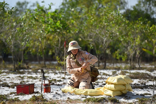 -Cette photo prise le 6 janvier 2020 montre un membre d'une équipe de déminage entièrement féminine se préparant à faire exploser des munitions non explosées sur un site de mines terrestres dans le district de Trieu Phong dans la province de Quang Tri. Photo de Nhac NGUYEN / AFP via Getty Images.