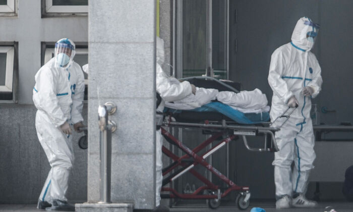 Le 18 janvier 2020, des membres du personnel médical transportent un patient à l'hôpital de Jinyintan, où sont traités les patients atteints de pneumonie de Wuhan, à Wuhan, dans la province centrale du Hubei, en Chine. (STR/AFP via Getty Images)