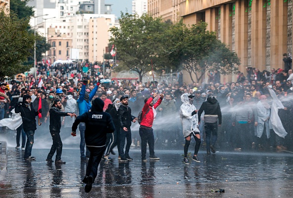 -Les forces de sécurité pulvérisent des canons à eau sur les manifestants lors d'affrontements dans le centre-ville de Beyrouth, près du siège du Parlement, le 18 janvier 2020. Photo par ANWAR AMRO / AFP via Getty Images.