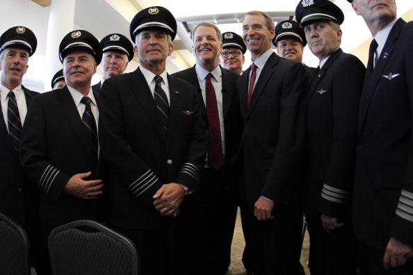 -Illustration- Doug Parker président et chef de la direction d'US Airways, et Thomas Horton président, président et chef de la direction d'American Airlines se tiennent avec des pilotes d'American Airlines et US Airways, lors d'une conférence de presse. Photo de Donna McWilliam / Getty Images.