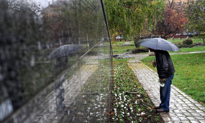 Un homme cherche les noms de ses proches sur un monument portant les noms de quelque 20 000 victimes du régime communiste, au centre de Sofia, capitale de la Bulgarie. (Dimitar Dilkoff/AFP via Getty Images)