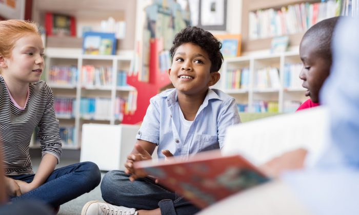 Un groupe d'enfants assis sur le sol en cercle autour d'un enseignant et écoutant une histoire. (Shutterstock)