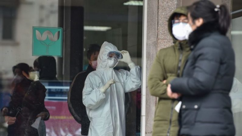  Une infirmière (C), portant des vêtements de protection pour aider à arrêter la propagation du virus mortel qui a commencé dans la ville, regarde un thermomètre au cinquième hôpital de Wuhan, à Wuhan, en Chine, le 24 janvier 2020. (Hector Retamal/AFP via Getty Images) 