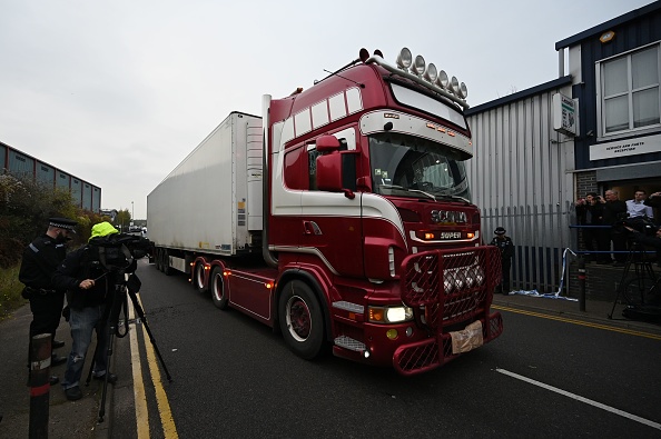 -Des policiers chassent un camion dans lequel 39 cadavres ont été découverts, ce qui a déclenché une enquête sur un meurtre dans le parc industriel de Waterglade à Grays, à l'est de Londres, le 23 octobre 2019. Photo de BEN STANSALL / AFP via Getty Images.