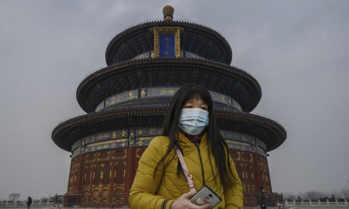 Une Chinoise porte un masque de protection lors de sa visite à Pékin, en Chine, le 27 janvier 2020. (Kevin Frayer/Getty Images)