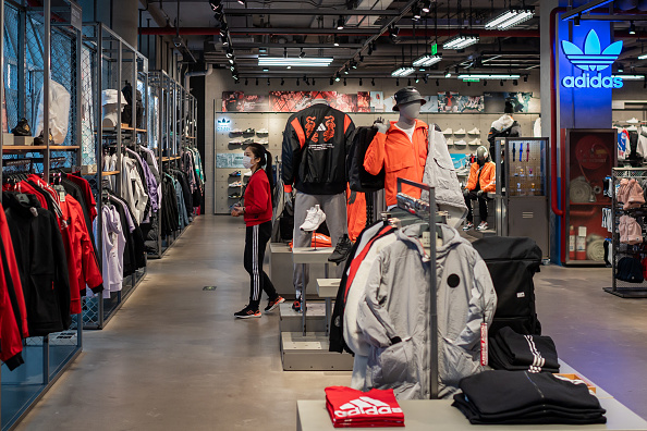 -Le 30 janvier 2020, un vendeur, portant un masque facial, attend des clients dans une boutique Adidas vide à Pékin. Photo de NICOLAS ASFOURI / AFP via Getty Images.