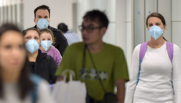 Les passagers, portant des masques par mesure de précaution pour éviter de contracter le virus Covid-19, transitent par l'aéroport international de Guarulhos, à Guarulhos, Sao Paulo, Brésil le 26 février 2020. (Photo : NELSON ALMEIDA/AFP via Getty Images)