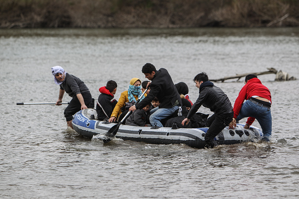 Les réfugiés et les migrants utilisent un bateau lorsqu'ils tentent d'entrer en Grèce depuis la Turquie en traversant le fleuve Evros le 29 février 2020 à Edirne, en Turquie. La Turquie a annoncé qu'elle ouvrirait des portes frontalières pour une période de 72 heures afin de permettre aux réfugiés de pénétrer dans les pays européens.(Photo : Osman Orsal/Getty Images)