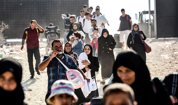 Des réfugiés syriens arrivent à la porte de passage d'Oncupinar, près de la ville de Kilis, au centre-sud de la Turquie. (Photo : BULENT KILIC/AFP via Getty Images)