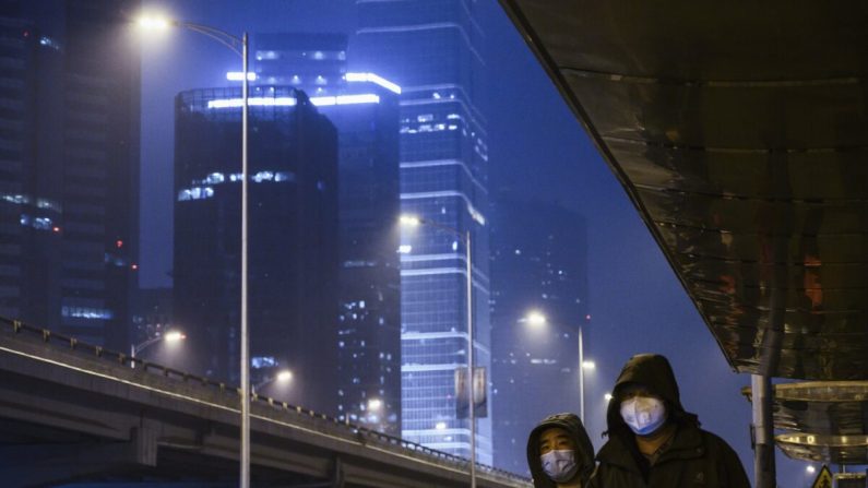 Des citoyens portent des masques de protection en attendant le bus dans une rue presque vide du quartier central des affaires, normalement très fréquenté, à l'heure de pointe du vendredi 7 février 2020 à Pékin, en Chine. (Kevin Frayer/Getty Images)