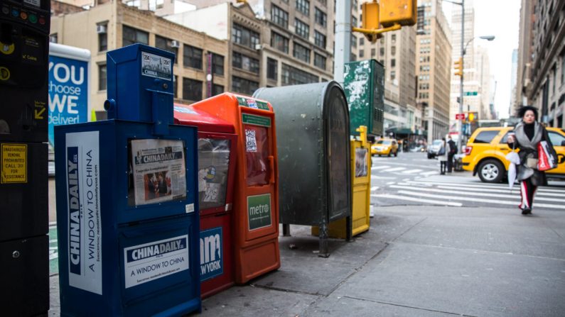 Une boîte à journaux payante du China Daily est présente avec d'autres quotidiens gratuits dans le Midtown Manhattan le 6 décembre 2017. (Benjamin Chasteen/The Epoch Times)