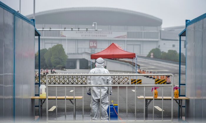 Une personne de l'équipe médicale portant un équipement de protection regarde à l'extérieur d'un hôpital de fortune à Wuhan, dans la province centrale de Hubei, en Chine. - Le 24 février, les autorités chinoises ont légèrement assoupli leurs mesures de quarantaine d'un mois à Wuhan, permettant à certaines personnes de quitter l'épicentre de l'épidémie de virus du pays sous certaines conditions, le 22 février 2020. (STR/AFP via Getty Images)